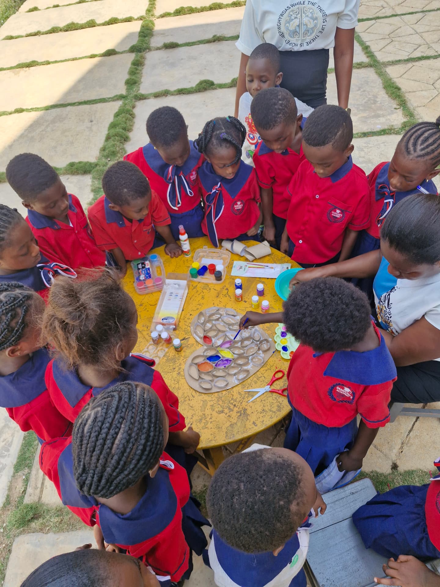 Young learners gathered around a table for a painting and craft activity